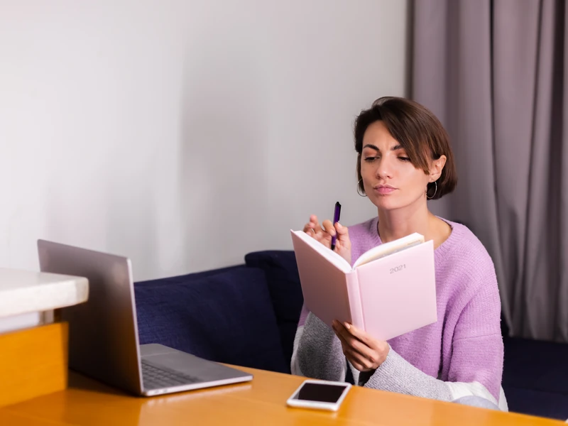 Người học ngồi lên kế hoạch chi trả vào sổ tay bên máy tính