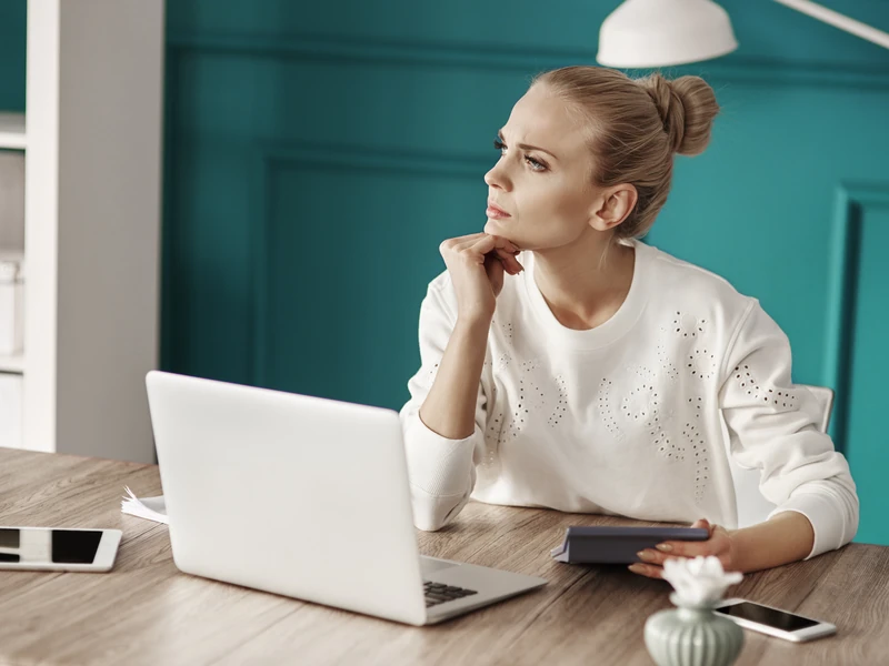 Người học ngồi tính toán ngân sách bên laptop và tập giấy tờ